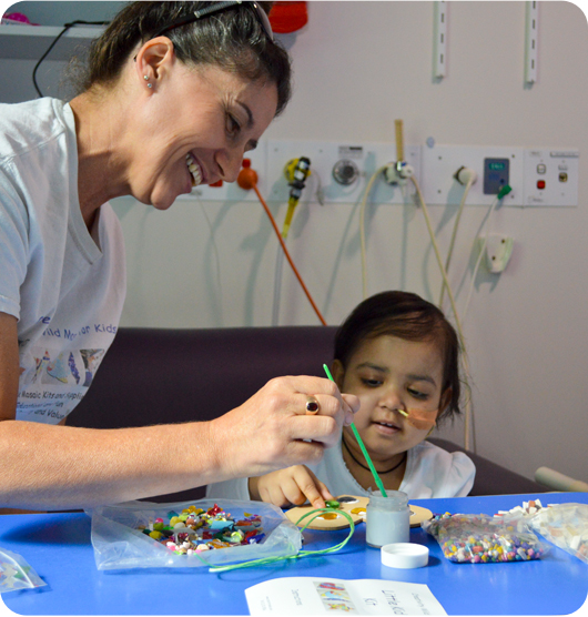 A young girl and an Art Therapist creating art with beads