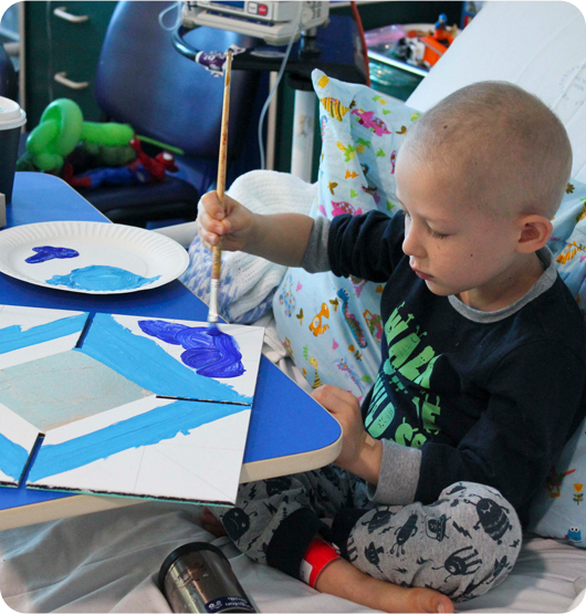 A young child in hospital paiting with a deep blue colour