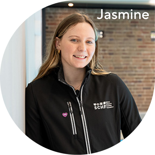 Jasmine Greenwood wearing a SCHF sweater standing in front of a swimming pool