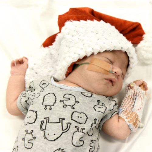 A newborn hospital patient wearing a santa hat