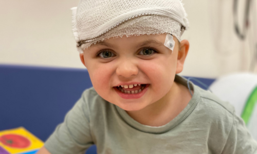 Noah in hospital with bandages around his head