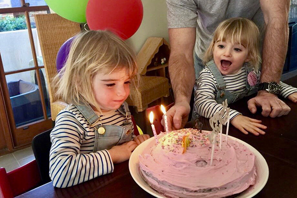 Jasmine and Jacinta blowing out the candles on their birthday cake