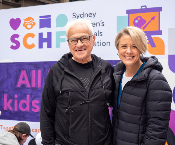 Professor Les White and SCHF CEO Kristina Keneally standing in front of a large SCHF artwork at Martin Place in Sydney.