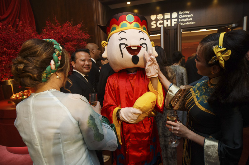 A man dressed up as Nian Wa (年娃) 'New Year Boy' and attendees at the Lunar new year celebration 2025