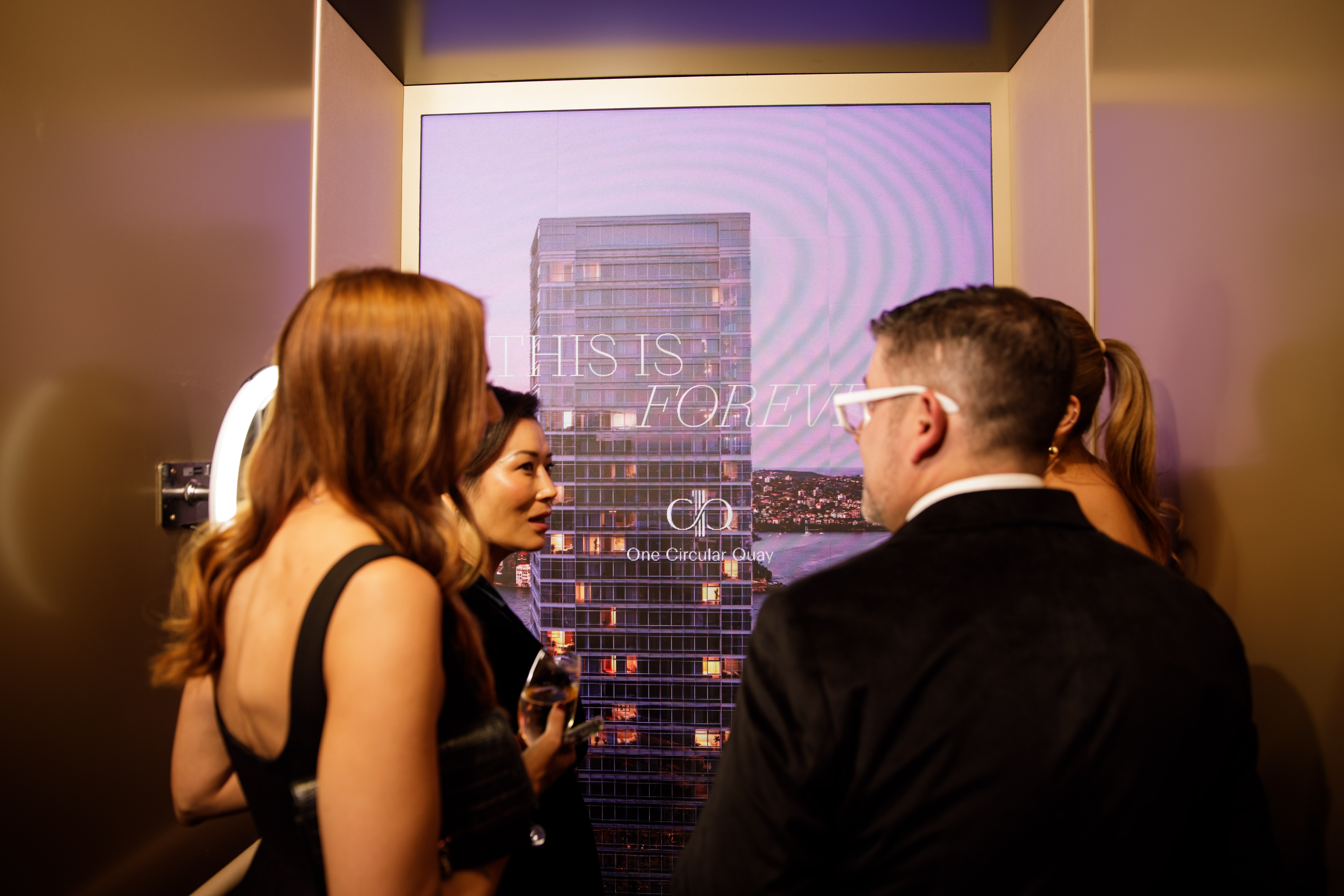 Image of four people standing inside One Circular Quay Lendlease elevator.
