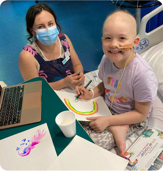 A young girl and an Art Therapist drawing a rainbow