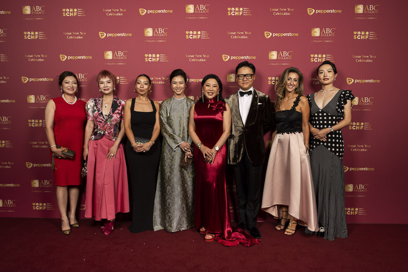 Lunar New Year Celebration Committee dressed up in stunning attire in front of the media wall