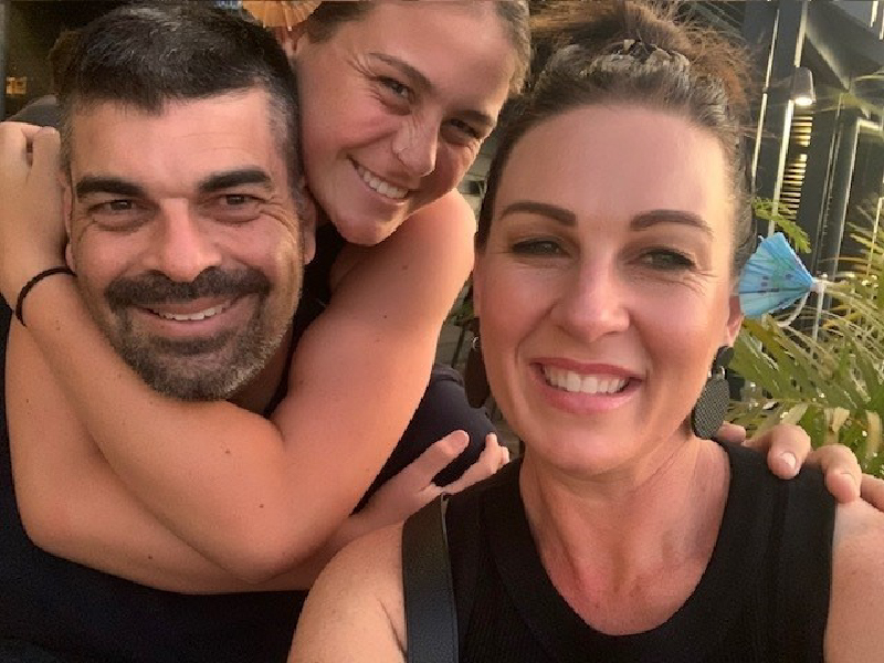 Maddie and her parents smiling and hugging Maddie and her parents smiling and hugging