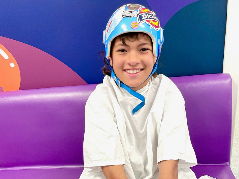 Remy wearing his blue medical helmet while sitting on a purple hospital chair