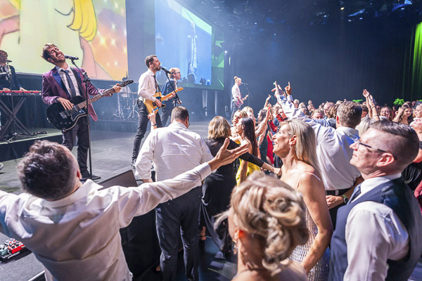 The band performing on stage at Emerald Ball 2025 to the audience as they dance