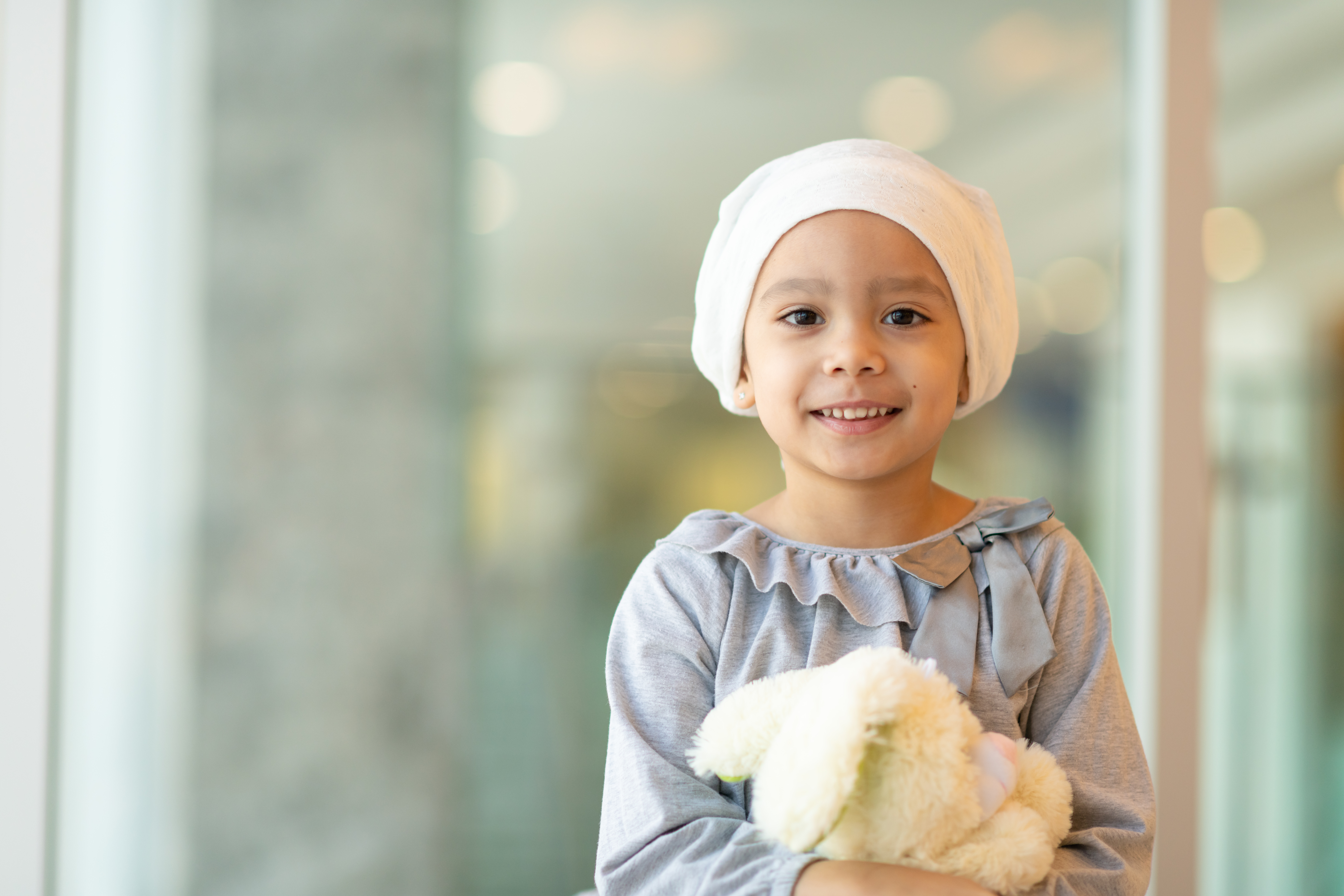 Image of young child smiling standing in front of blurred background. Image of young child smiling standing in front of blurred background.