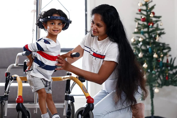 Kiveyn and his mum at Christmas time, a Christmas tree in the background