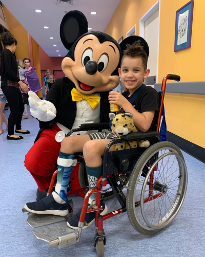 Hugo getting a photo with Mickey Mouse in hospital