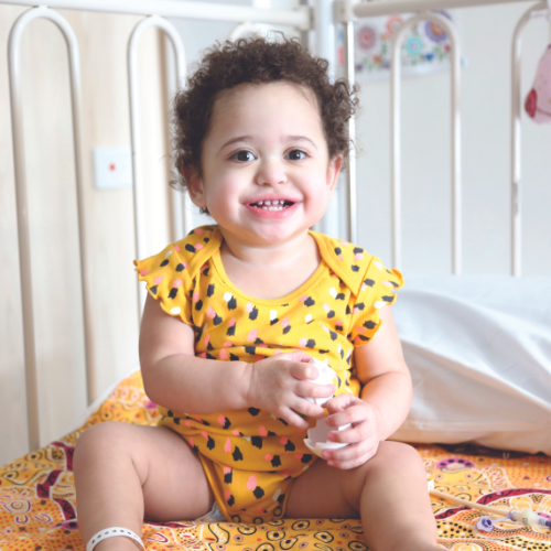 Lani sitting on her bed