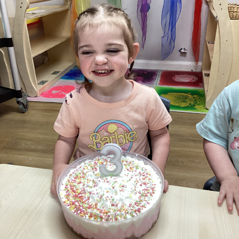Abigail celebrating her third birthday with an ice cream cake.