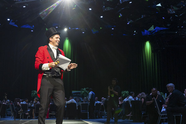 Emerald Ball's host dressed as a Circus ringleader speaking on stage at Emerald Ball 2025