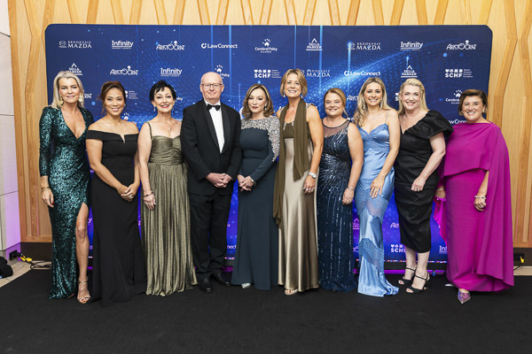 A group of attendees in front of a media wall at Grace Gala 2025