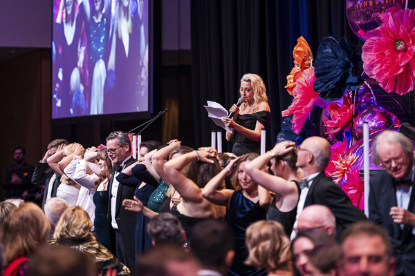 Attendees standing in front of the stage playing heads or tails at Grace Gala 2025