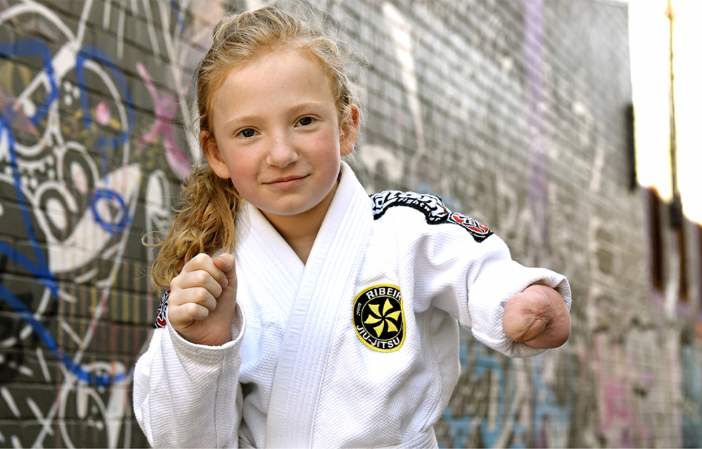 Young girl with one arm wearing Jiu-jitsu garb