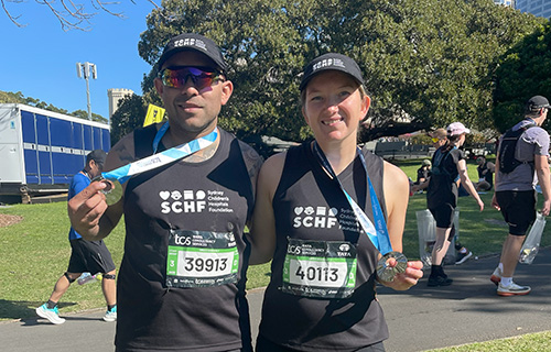 Two runners showing off their medals after the TCS Sydney Marathon