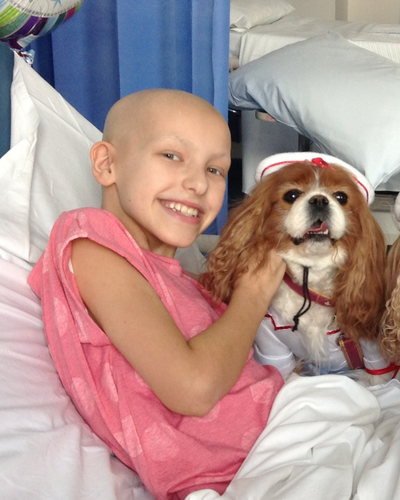 Eve in hospital bed with dog