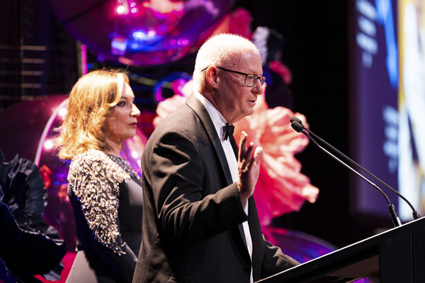 A speaker on stage talking to the audience at Grace Gala 2025