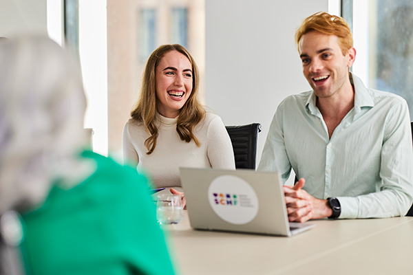 SCHF Employees in a meeting room smiling