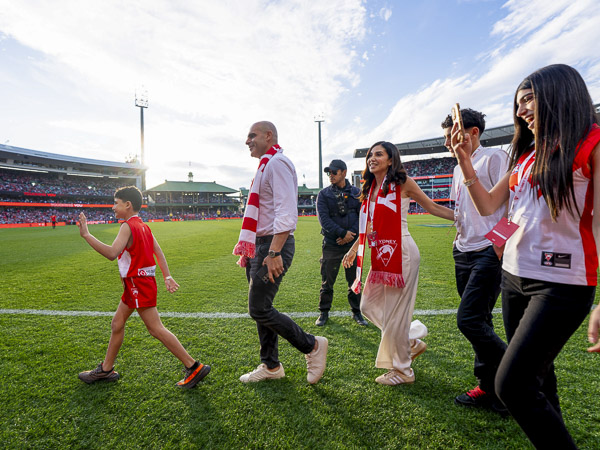 A family of supporters walking out onto the field at a Sydney Swans match