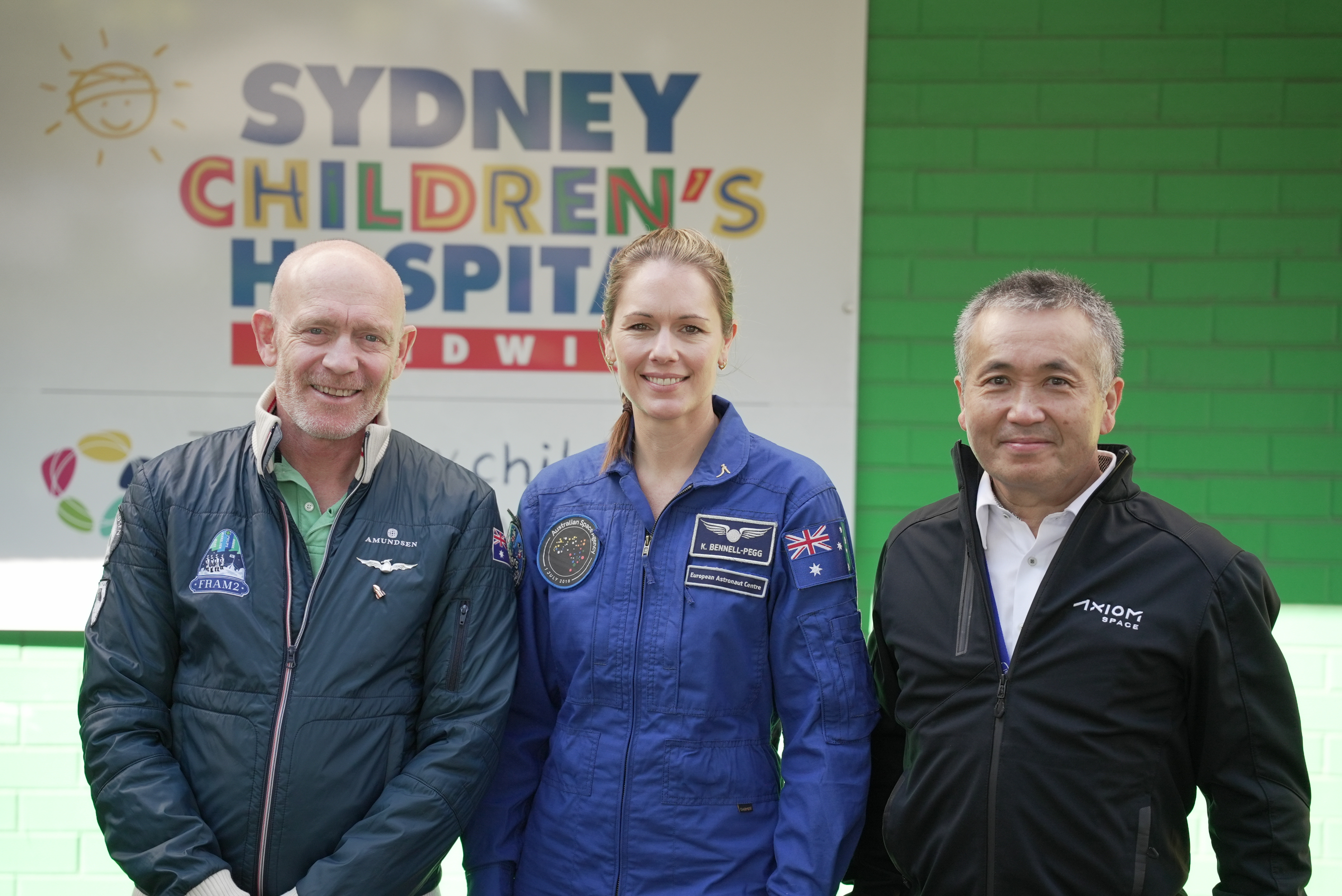 Image of three astronauts standing together smiling outside Sydney Children's Hospital, Randwick.