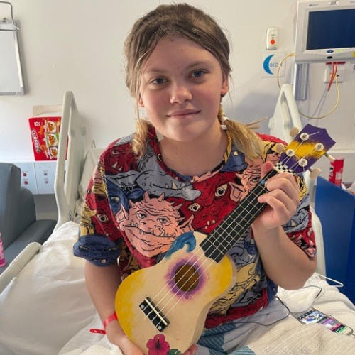 A young hospital patient holding a ukulele