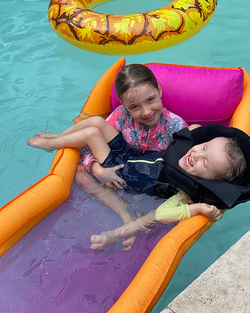 Archie and his sister swimming in a pool