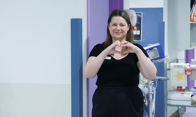 Image of nurse educator doing heart hands in hospital.