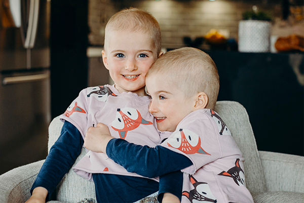 Jasmine and Jacinta hugging while wearing matching outfits