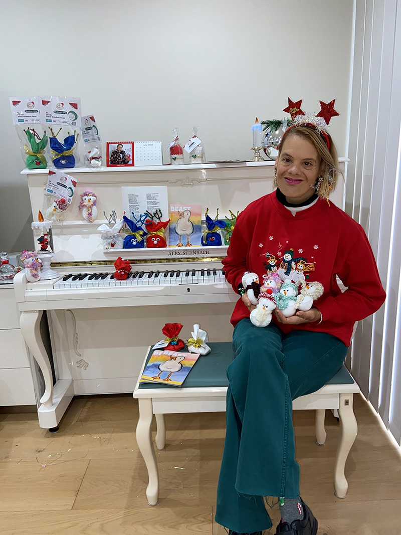 Marie at her home holding some of her craft works