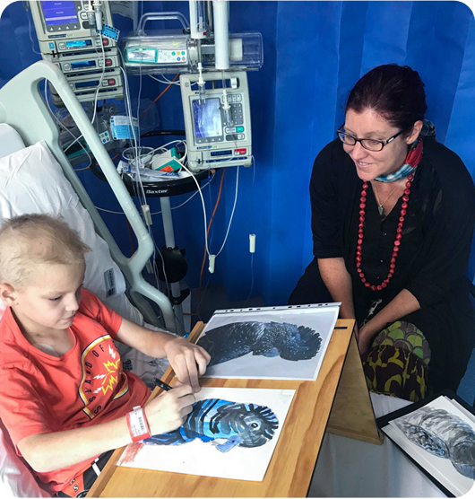 A young boy drawing a blue parrot