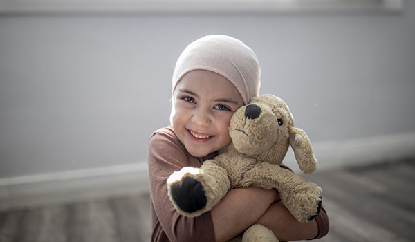 A young girl holding a teddy bear tightly with a huge grin A young girl holding a teddy bear tightly with a huge grin