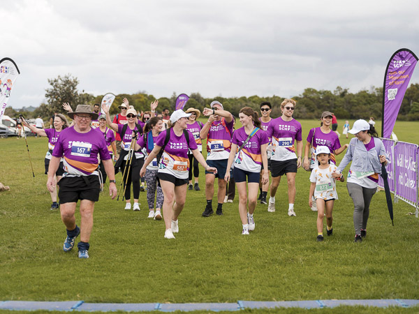 A group of people cheering as they finish the Walk for Kids with Cancer