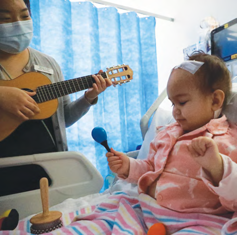 Laili shaking a maraca taking part in Music Therapy